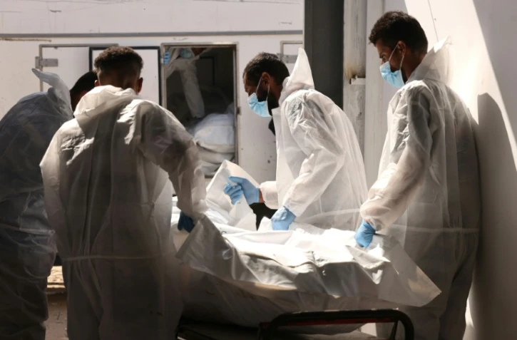 Des employés de l'hôpital Nasser à Khan Younès dans le sud de la bande de Gaza transportent l'une des dépouilles remises à Gaza par les autorités israéliennes, via la Croix-Rouge, le 31 octobre 2025