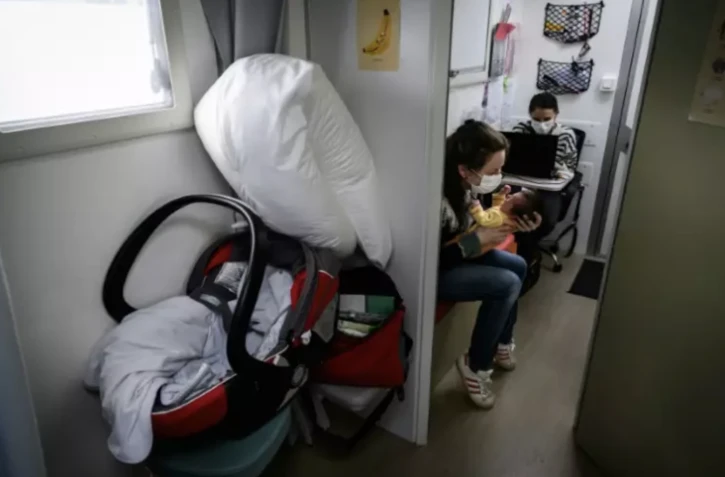 Une sage-femme rencontre une jeune mère et son nouveau-né lors d'une consultation médicale dans le véhicule de l'unité médicale mobile à Condat, dans le Cantal, le 28 mars 2024 ( AFP / JEAN-PHILIPPE KSIAZEK )
