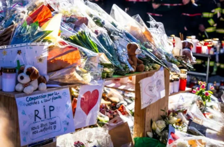 Photo le 4 janvier 2026 de fleurs et messages en hommage aux victimes de l'incendie d'un bar à Crans-Montana, en Suisse ( AFP / MAXIME SCHMID )