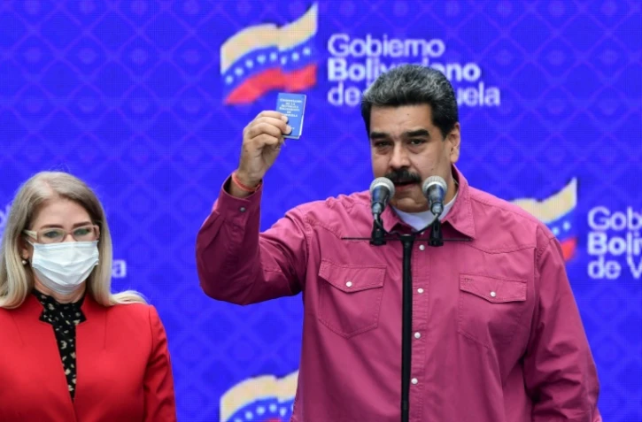 Le président du Venezuela  Nicolas Maduro avec sa femme  Cilia Flores, s'exprime lors d'une conférence de presse dans un bureau de vote à Caracas, le 6 décembre 2020