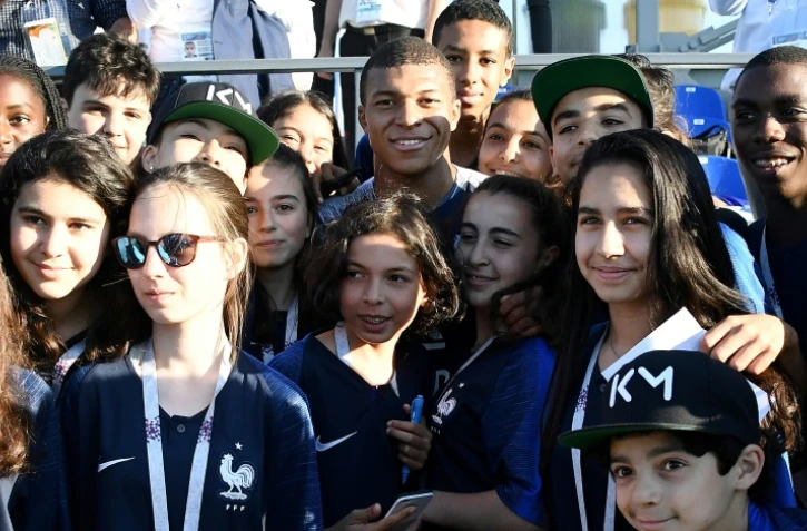 Kylian Mbappé (c) pose avec des jeunes supporters de Bondy, commune du club de son enfance, à la fin d'un entraînement lors du Mondial, le 27 juin 2018 à Istra   