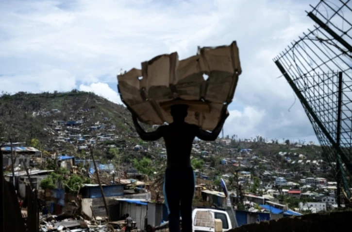 Un homme transporte des matériaux pour reconstruire sa maison à Mamoudzou, à Mayotte, le 2 janvier 2025 ( AFP / JULIEN DE ROSA )