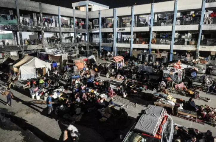 Des Palestiniens déplacés après un ordre d'évacuation israélien à Khan Younès s'apprêtent à passer la buit dans la cour d'une école dans le sud de la bande de Gaza, le 8 août 2024 ( AFP / Bashar TALEB )