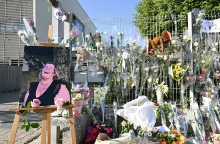 Des fleurs en hommage à la surveillante poignardée à mort devant les grilles du collège Françoise-Dolto de Nogent, en Haute-Marne le 13 juin 2025 ( AFP / FRANCOIS NASCIMBENI )