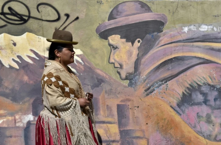 Alwa, première rappeuse aymara, passe devant une fresque murale à El Alto, en Bolivie, le 19 avril 2022