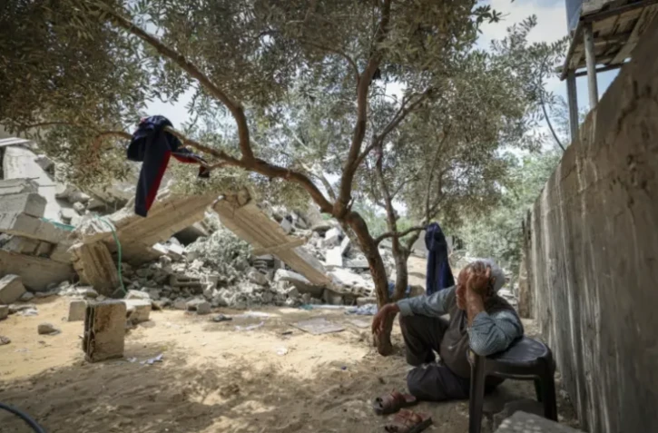 Photo prise le 15 mai 2023 montrant un membre de la famille palestinienne Nabhane assis près des décombres de sa maison, détruite par une frappe israélienne à Beit Lahya dans le nord de la bande de Gaza ( AFP / MAHMUD HAMS )