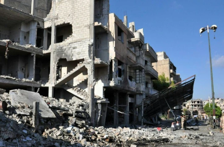 Photo fournie par l'agence officielle syrienne Sana montrant des soldats syriens inspectant les lieux d'un attentat à la bombe à Homs, le 5 septembre 2016