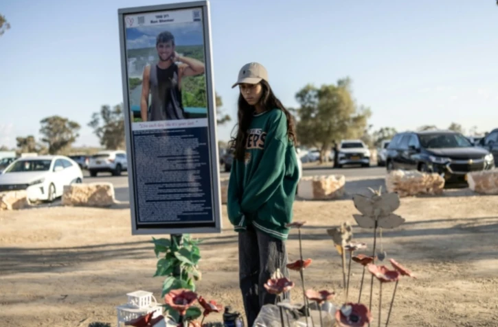 Une femme se recueille le 7 octobre 2025 devant le mémorial d'une victime de l'attaque du Hamas au festival Nova deux ans plus tôt, à Réïm, dans le sud d'Israël ( AFP / JOHN WESSELS )