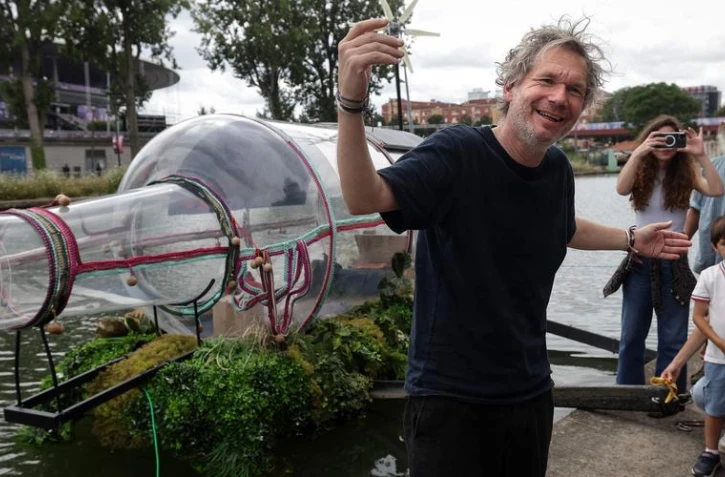 Lâartiste performeur Abraham Poincheval Ă sa sortie, samedi, de la bouteille installĂ©e sur le Canal de lâOurq Ă Saint-Denis.