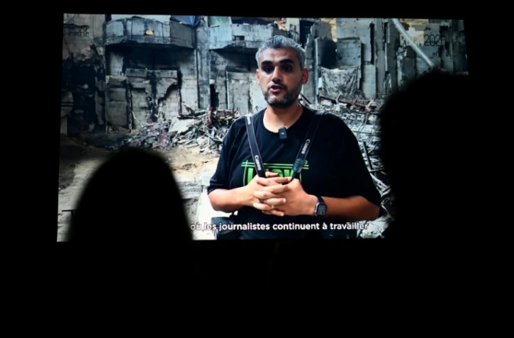 Le photographe palestinien Mahmoud Abu Hamda prononce un discours préenregistré, diffusé sur écran, après avoir reçu le prix du jury international de l'édition 2026 du Prix Bayeux Calvados-Normandie des correspondants de guerre, à Bayeux, le 10 octobre 2026