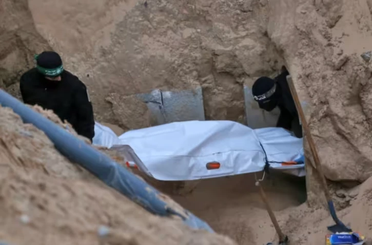 Des combattants cagoulés du Hamas transportent un corps retrouvé dans un tunnel au nord de Khan Younès, dans le sud de la bande de Gaza, le 28 octobre 2025 ( AFP / Bashar TALEB )