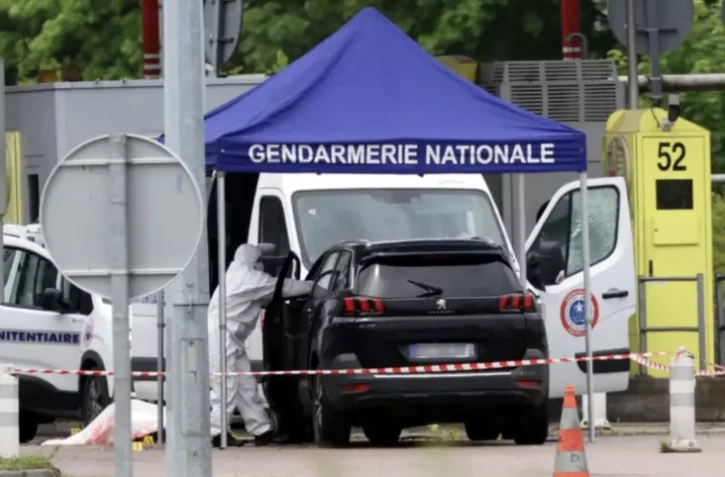 Un médecin légiste sur le site d'une attaque à la voiture bélier contre un fourgon pénitentiaire, au péage routier à Incarville, dans l'Eure, le 14 mai 2024 ( AFP / ALAIN JOCARD )