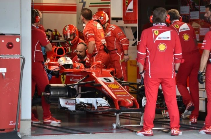 Le pilote Ferrari Sebastian Vettel en arrêt au stand entouré par les mécaniciens lors du GP du Japon, le 8 octobre 2017 à Suzuka