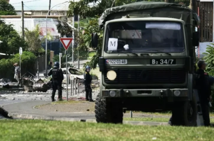Des gendarmes positionnés dans un quartier de Nouméa, le 14 mai 2024 en Nouvelle-Calédonie ( AFP / Theo Rouby )
