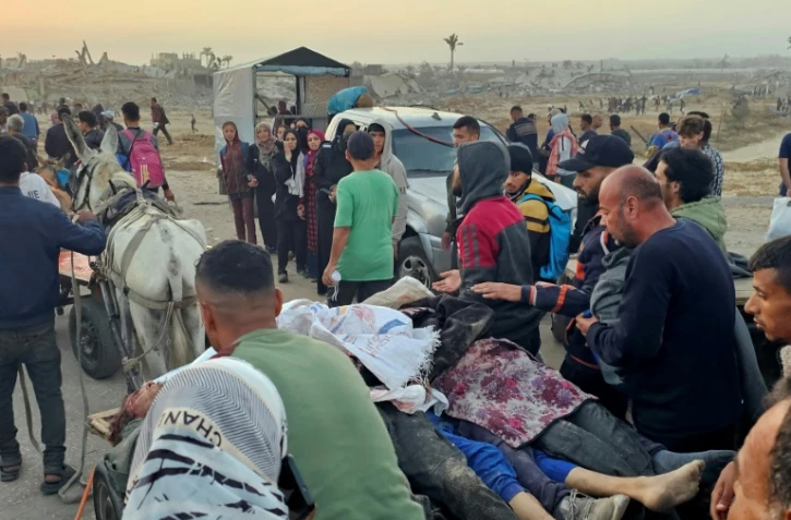 Des Gazaouis évacuent des personnes tuées, selon la Défense civile locale, par des tirs israéliens en marge d'une distribution d'aide à Rafah, dans le sud de la bande de Gaza, le 1er juin 2025