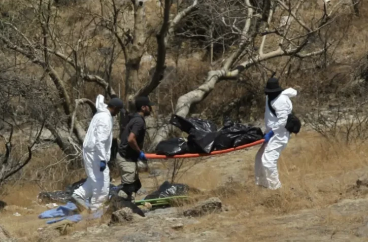 La police scientifique extrait plusieurs sacs contenant des restes humains d'un ravin à Zapopan, au Mexique, le 31 mai 2023 ( AFP / ULISES RUIZ )