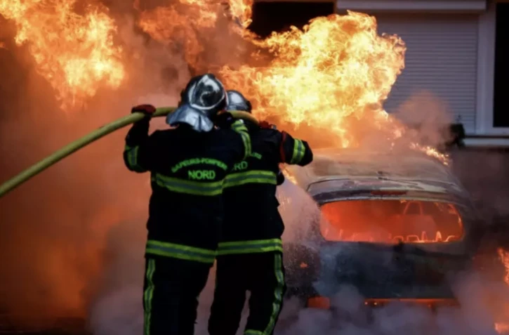Les pompiers interviennent sur une voiture incendiée pendant des violences à Lille, le 29 juin 2023 ( AFP / KENZO TRIBOUILLARD )