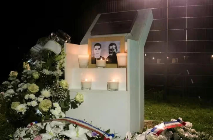 Des fleurs déposées près d'une plaque érigée à la mémoire de Bouna Traoré (d) et Zyed Benna,