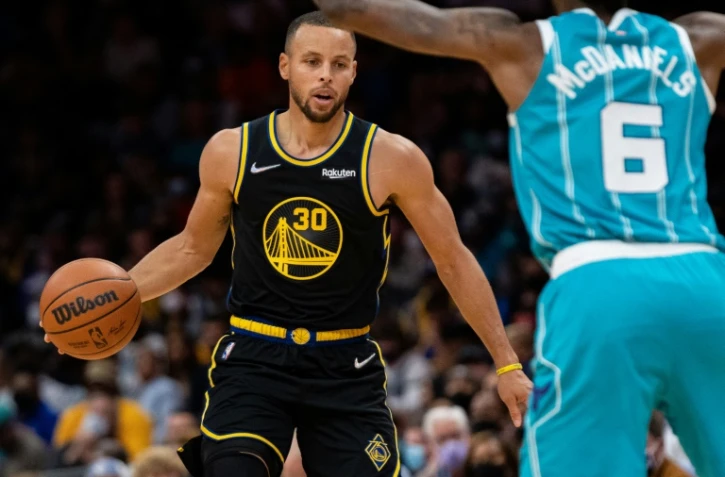 Stephen Curry des Golden State Warriors face au joueur des Charlotte Hornets Jalen McDaniels au Spectrum Center de Charlotte, le 14 novembre 2021