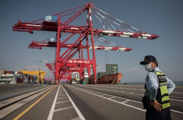 Un agent de sureté surveille le chargement de porte-conteneurs amarrés le long des quais du terminal portuaire de Séoul, le 3 septembre 2016