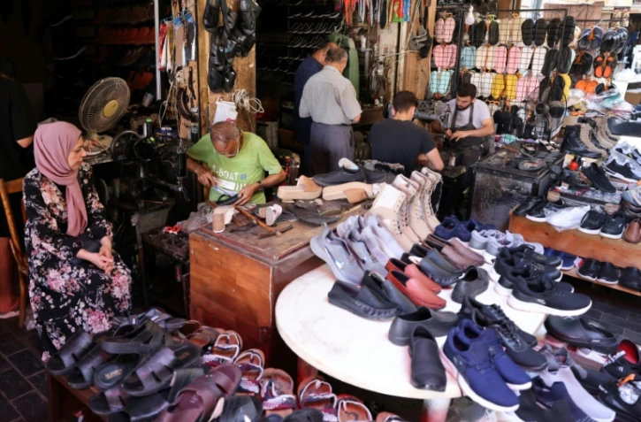 Des ouvriers réparent des chaussures pendant que des clients attendent dans la cordonnerie d'Ahmed al-Bizri, dans la ville côtière de Sidon (Saïda en arabe), au Liban, le 11 juillet 2023