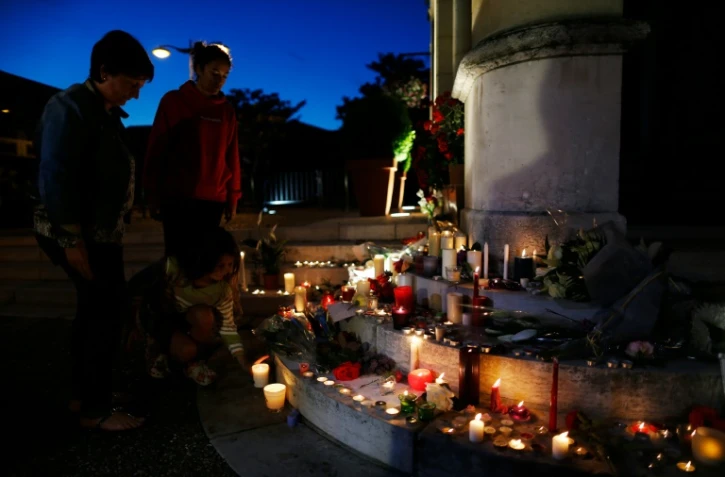 Des gens allument des bougies à Saint-Etienne du Rouvray le 26 juillet 2016