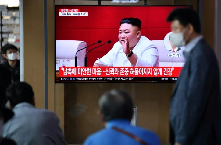 Des Sud-Coréens regardent des images du leader nord-coréen Kim Jong Un sur un écran de télévision dans une gare de Séoul, le 25 septembre 2020