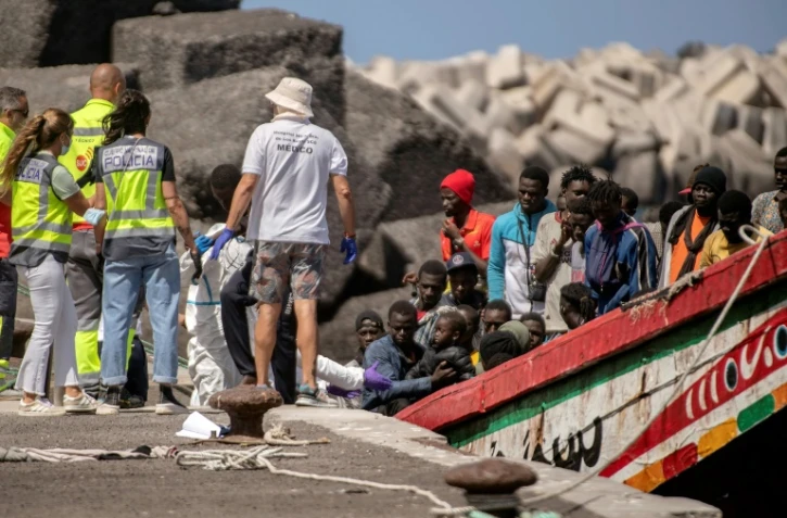 Des membres des forces de police et des services d'urgence aident des migrants à leur arrivée au port de Restinga sur l'île d'El Hierro, le 18 août 2024 aux Canaries