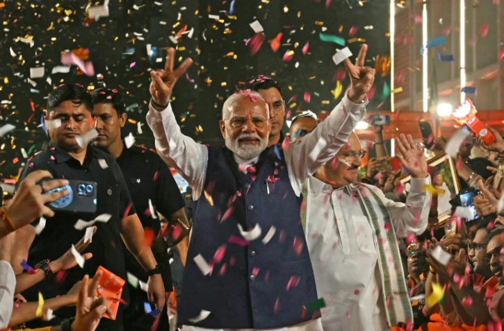 Le Premier ministre indien Narendra Modi fait le signe de la victoire en arrivant au siège de son parti, le BJP, le 4 juin 2024 à New Delhi