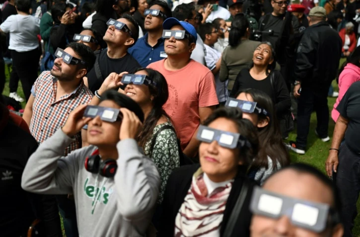 Des personnes regardent l'éclipse solaire annulaire au planétarium Luis Enrique Erro de l'Institut polytechnique national (IPN) à Mexico, le 14 octobre 2023