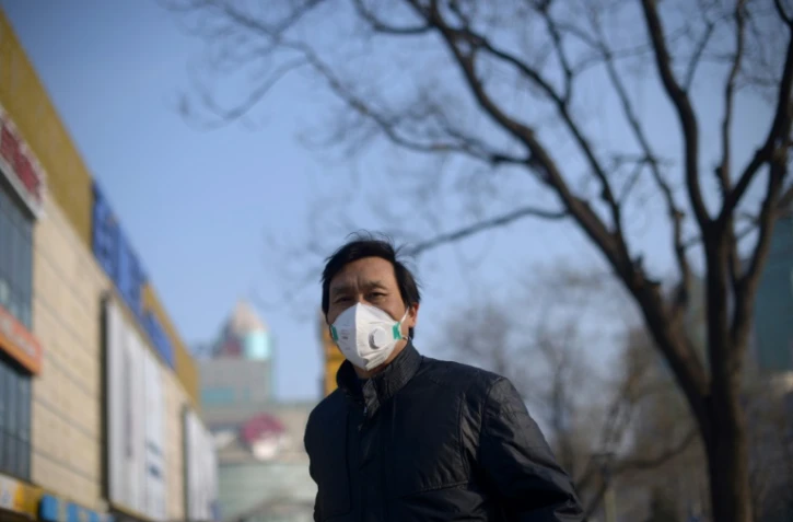 Un homme porte un masque pour se protéger de la pollution le 23 décembre 2015 à Pékin