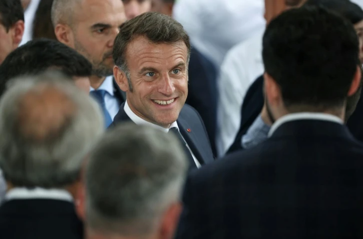 Le président français Emmanuel Macron (au centre) assiste à l'inauguration d'un laboratoire à Wissous, en région parisienne, le 12 mai 2025