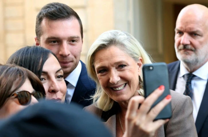 La présidente du groupe RN à l'Assemblée nationale Marine Le Pen pose pour un selfie dans la cour de l'Hôtel Matignon à Paris le 17 septembre 2025