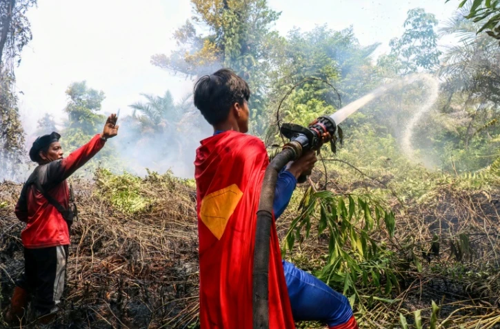 'adolescent indonésien Rudiansyah porte un costume de "Superman" en combattant un incendie, à Palangkaraya, dans le Kalimantan central, le 17 août 2026