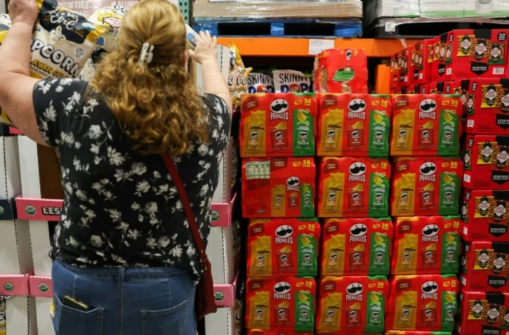 Une cliente choisit des pop-corns, devant un étalage de chips "Pringles", dans un supermarché d'Hawthorne, en Californie, le 2 décembre 2025