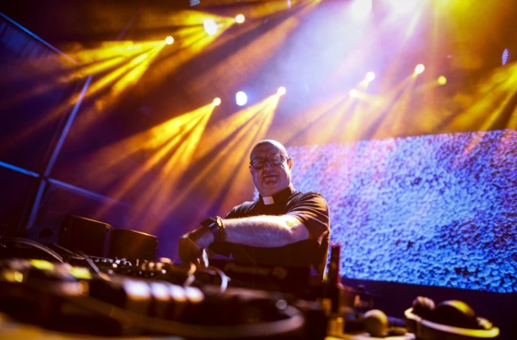 Le prĂȘtre et DJ Guilherme Peixoto, sur scĂšne lors d'une fĂȘte populaire Ă Coimbra, le 4 juillet 2024 au Portugal