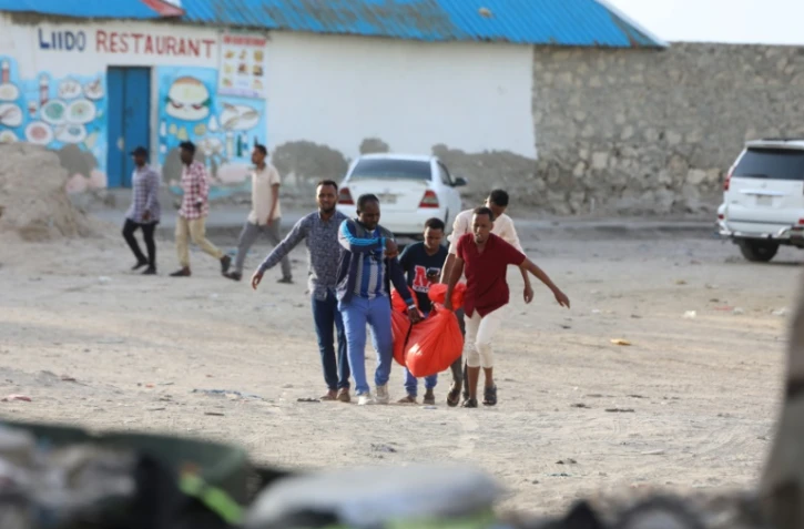 Des hommes transportent le cadavre d'une de leurs proches le 3 août à Mogadiscio en Somalie, tuée lors d'un attentat la veille sur la plage du Lido 