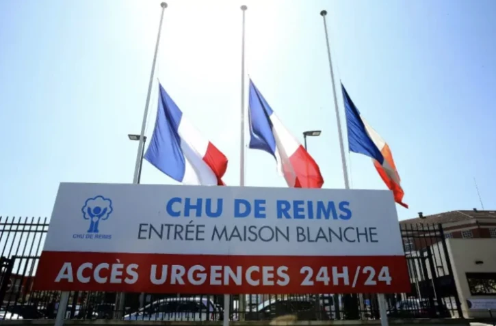 Drapeaux tricolores en berne à l'entrée de l'hôpital de Reims où a été mortellement blessée une infirmière, le 24 mai 2023 ( AFP / FRANCOIS NASCIMBENI )