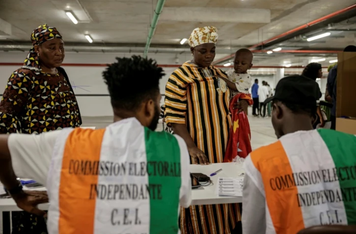Des représentants de la commission électorale supervisent les opérations de vote pour la présidentielle ivoirienne, à Abidjan le 25 octobre 2025
