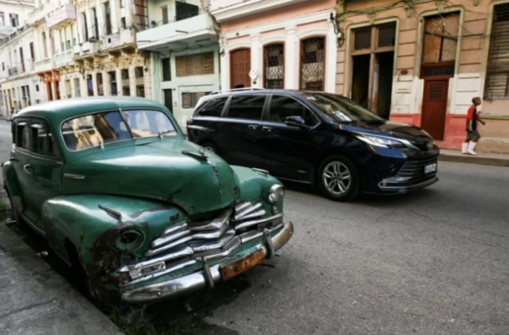 Une vieille voiture américaine (g) et une berline neuve dans une rue de La Havane, le 4 septembre 2024 à Cuba ( AFP / YAMIL LAGE )