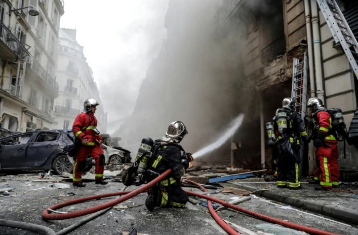 Des pompiers éteignent un incendie à la suite de l'explosion d'une boulangerie, à l'angle des rues Sainte-Cécile et de Trévise, dans le centre de Paris, le 12 janvier 2019
