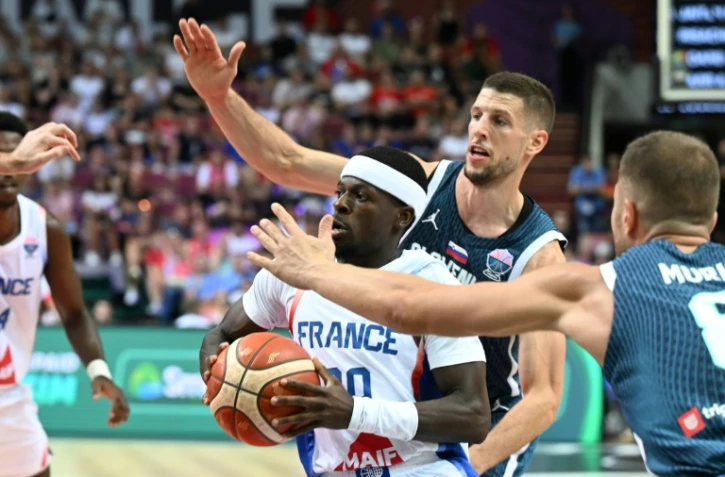 Inarrêtable, le meneur de jeu de l'équipe de France Sylvain Francisco résiste aux Slovènes Edo Muric et Gregor Hrovat dans le groupe D de l'Euro à Katowice, le 30 août 2025