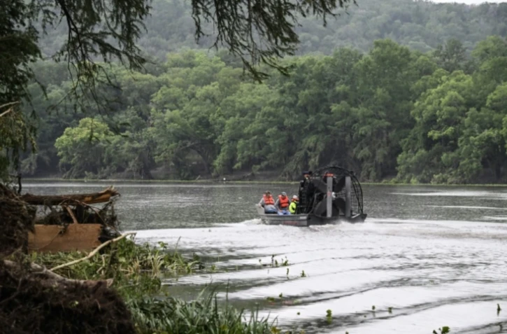Des sauveteurs à bord d'un bateau pneumatique sur le fleuve Guadalupe recherchent des personnes portées disparues après les inondations subites à Hunt, dans l'Etat américain du Texas, le 6 juillet 2025 ( AFP / RONALDO SCHEMIDT )