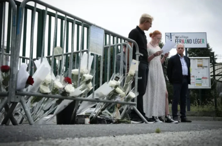 Des élèves rendent hommage, le 15 août 2023 à Livarot (Calvados), à Stéphane Vitel, leur ancien professeur, devenu principal d'un collège de Lisieux, où celui-ci a été retrouvé mort quatre jours aupravant ( AFP / LOU BENOIST )