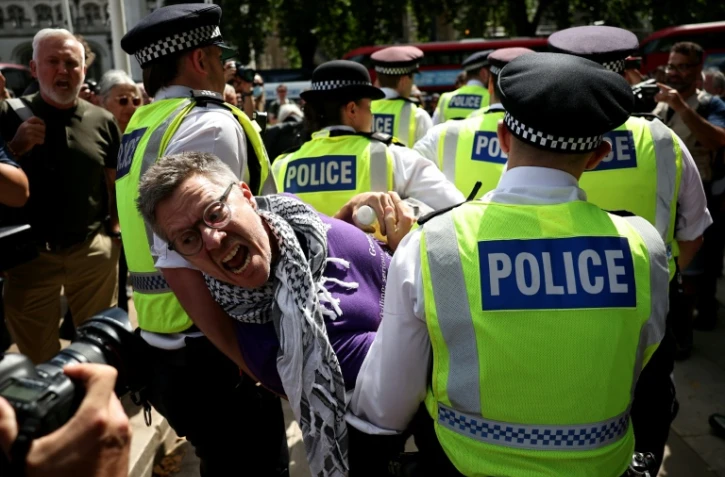 Un manifestant est emmené par des policiers lors d'une manifestation « Lift The Ban » (Lève l'interdiction) en soutien au groupe interdit Palestine Action, qui réclame la levée de l'interdiction récemment imposée, sur Parliament Square, dans le centre de Londres, le 9 août 2025