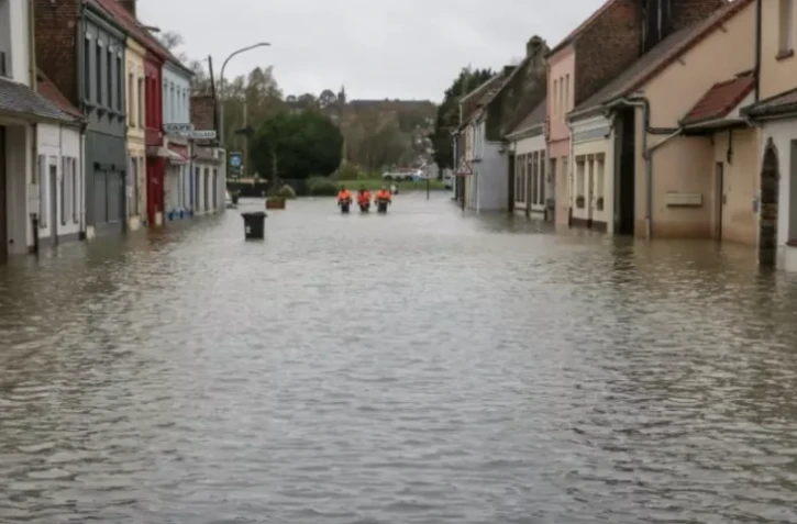 Des employés municipaux dans une rue inondée de Neuvile-sous-Montreuil, le 13 novembre 2023 dans le Pas-de-Calais ( AFP / DENIS CHARLET )