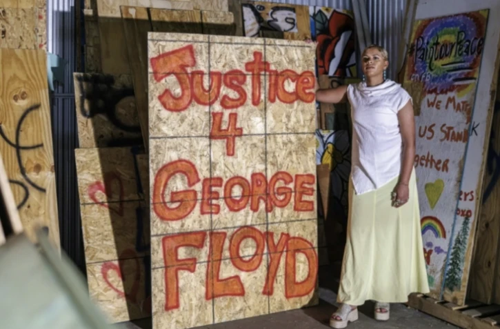Kenda Zellner-Smith pose dans un container de stockage avec un des panneaux de bois qu'elle a collectés en 2020 après la mort de George Floyd, le 25 mai 2025 à Minneapolis, dans le Minnesota ( AFP / Kerem YUCEL )