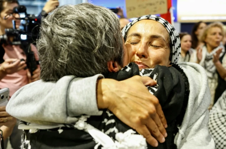 Une militante française, détenue et expulsée par Israël après l'interception de la flottille pour Gaza, embrasse une proche à son arrivée à l'aéroport Roissy-Charles-de-Gaulle, le 22 mai 2026, au nord de Paris