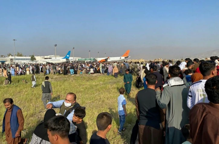 Des Afghans attendent à l'aéroport de Kaboul de pouvoir quitter la capitale, le 16 août 2021