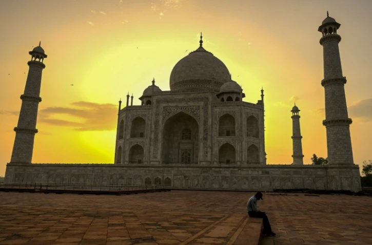 Un gardien du Taj Mahal se repose au lever du soleil le 16 juin 2021, jour de la réouverture de ce monument à Agra en Inde
